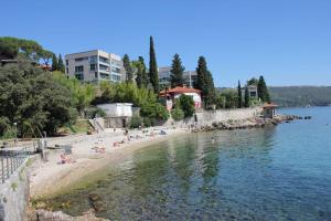 a group of people on a beach near the water at Apatmani Milena in Opatija