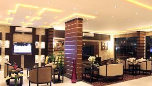 un vestíbulo con una sala de espera con mesas y sillas en Rest Night Hotel Suites - Al Nafal, en Riad