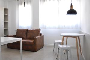 een woonkamer met een stoel en een tafel bij Residencia Universitaria Tarragona Mediterrani in Tarragona