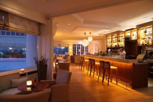 ein Restaurant mit Bar und einer Person im Hintergrund in der Unterkunft ATLANTIC Grand Hotel Travemünde in Travemünde