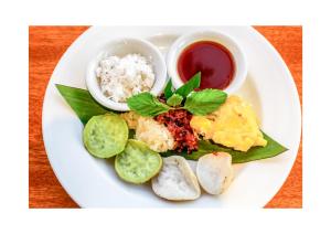 einen Teller mit Reis und Gemüse auf dem Tisch in der Unterkunft Japa House in Ubud