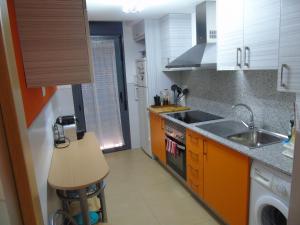 a kitchen with a sink and a stove top oven at Apartamentos Mequedo in Alcañiz