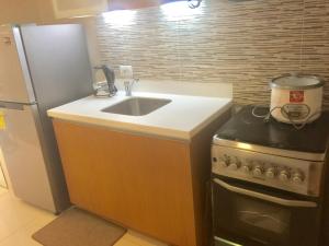 a kitchen with a sink and a refrigerator at ADC Condo 1 Bedroom Unit at Pico de Loro in Nasugbu