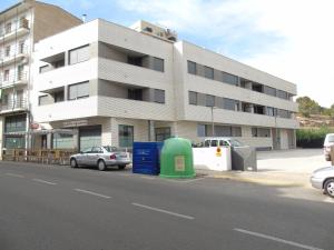 een gebouw met auto's geparkeerd voor een straat bij Apartamentos Mequedo in Alcañiz