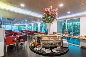 a restaurant with tables and chairs and a buffet at Anajak Bangkok Hotel - SHA Plus in Bangkok