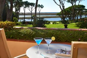 two martini glasses sitting on a table with a view at Hotel Quinta do Lago in Quinta do Lago