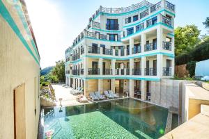 a building with a swimming pool in front of it at ApartHotel Prostor in Kavarna