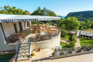a restaurant with tables and chairs on a patio at ApartHotel Prostor in Kavarna