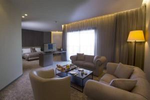 een woonkamer met banken en een woonkamer met een tafel bij Promenade Hotel in Beiroet