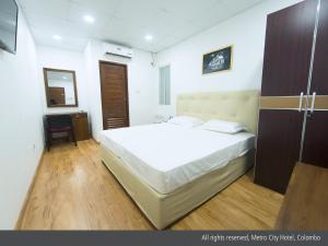 Postel nebo postele na pokoji v ubytování Metro City Hotel