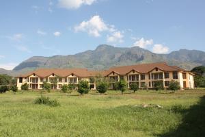 a large building with mountains in the background at Nashera Hotel in Morogoro