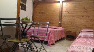 a room with a table and two chairs and a bed at Chalet Don Bosco in Castiglione di Sicilia