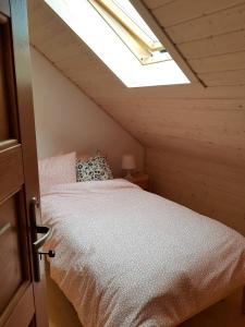 ein Schlafzimmer mit einem Bett im Dachgeschoss mit einem Dachfenster in der Unterkunft Szumimorze in Rusinowo