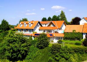 una fila de casas con techos naranjas en una colina en Die Herberge am Lautenberg Bad Loipersdorf en Loipersdorf bei Fürstenfeld