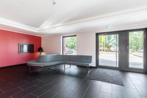 a living room with a couch and red walls at Serways Hotel Steigerwald in Wachenroth