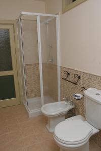 a bathroom with a toilet and a shower and a sink at B&B Palazzo Gambino in Acireale
