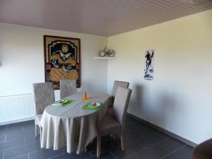 a dining room with a table with chairs and a painting at Le Petit Breuil in Verteillac +30 photos
