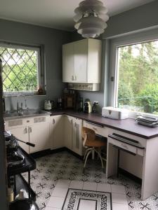 cocina con armarios blancos, fregadero y ventana en Villa Heidi, en Solingen