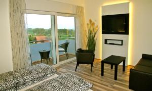 Pokój z łóżkiem i balkonem z telewizorem w obiekcie Hotel Restaurant Vogelsang w mieście Eich