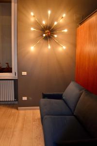 Carducci 2 - Charming & Cozy Apartment في ميلانو: غرفة معيشة مع أريكة وأضواء على الحائط