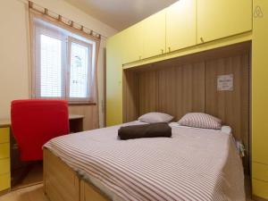 1 dormitorio con 1 cama grande con silla roja en Luxury front row designer apartment, en Selce