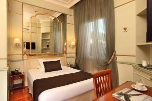 a bedroom with a bed and a table and a mirror at Hotel Degli Aranci in Rome