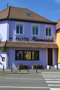 un hotel con un cartel en el lateral de un edificio en Hotel Restaurant Niemerich, en Pulversheim