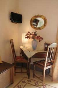 a table with a vase of flowers and a mirror at B&B Palazzo Gambino in Acireale
