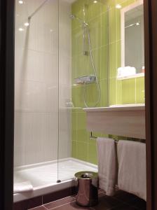 een badkamer met een douche, een toilet en een wastafel bij The Originals City, Hôtel des Lys, Dreux (Inter-Hotel) in Dreux
