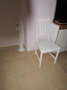 białe krzesło siedzące w rogu pokoju w obiekcie Appartamenti Di Laura w mieście Pastrengo