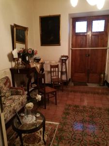 a living room with a couch and a table and a door at B&B Palazzo Gambino in Acireale