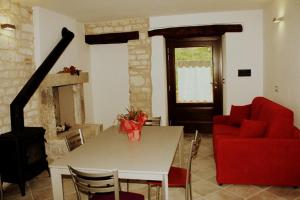 a living room with a table and a red couch at Casa Vacanze L'arco di Fondarca n.16 in Cagli