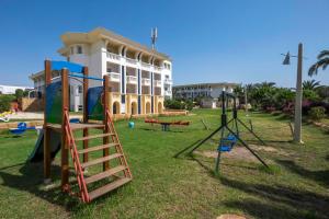 un parque infantil frente a un edificio en Medina Belisaire And Thalasso en Hammamet