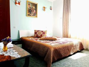 a small bedroom with a bed and a table at Pensiunea BRADU in Piatra Neamţ