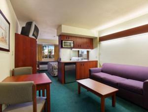 sala de estar con sofá púrpura y cocina en Microtel Inn & Suites by Wyndham Wellton, en Wellton