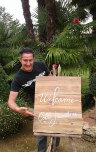 a man holding a sign that says welcome exit jordan at Cote jardin in Hontanx