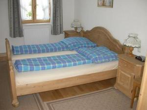 a bedroom with a bed with a blue plaid blanket at Ferienhaus Feuerer in Obertraun