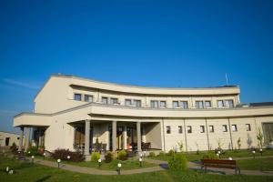 a large white building with a bench in front of it at Papillon in Piteşti
