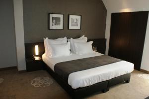 a bedroom with a large bed with white pillows at Hotel Restaurant Weinebrugge in Bruges