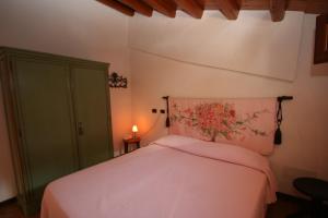 a bedroom with a pink bed with a green cabinet at La corte di Pietro in Isnello