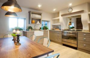 a kitchen with a wooden table and a dining room at Pheasants Nye in Higher Burwardsley