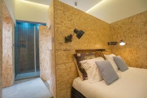 リスボンにあるTorel Loftの石壁のベッドルーム1室