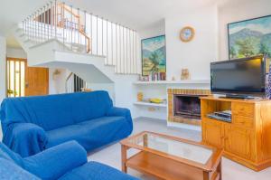 a living room with a blue couch and a tv at Ca Na Martina in Cala d´Or