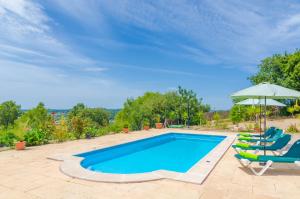 una piscina con 2 tumbonas y una sombrilla en Son Morey, en Vilafranca de Bonany