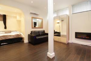 a bedroom with a bed and a chair and a mirror at Cumberland Apartments in London