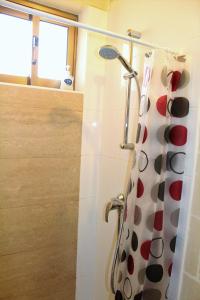 a bathroom with a shower with a spotted shower curtain at Avalon seaside studios - Gozo Bellevue Homes in Xlendi