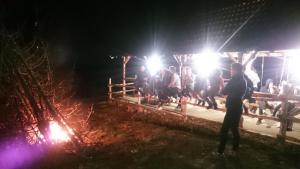 a group of people standing around a fence at night at Pensiunea Varful Roman in Horezu