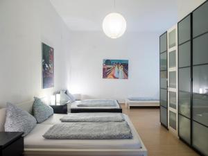 ein Wohnzimmer mit 3 Betten in der Unterkunft Großes Apartment in zentraler Lage in Berlin