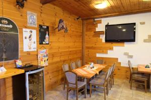 a dining room with a table and a flat screen tv at Penzion Rudolf in Liberec
