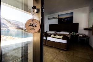 a room with a bed and a door with a sign at Mujib Chalets in Ath Thughrah